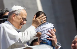 Papa Leão XIV abençoando uma criança depois da segunda audiência-geral de seu pontificado, em 28 de maio