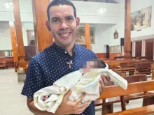 Padre Alejandro Enrique Ruiz Puerto com a bebê abandonada.