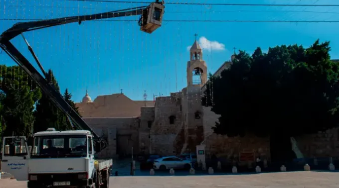 Trabalhadores retiram as luzes de Natal colocadas perto da Basílica da Natividade, em Belém. ?? 