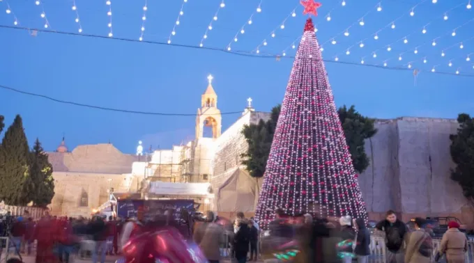 Pessoas se reúnem na Praça da Manjedoura, com uma árvore de Natal gigante, para celebrar a véspera de Natal de 2017 ?? 