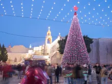 Pessoas se reúnem na Praça da Manjedoura, com uma árvore de Natal gigante, para celebrar a véspera de Natal de 2017