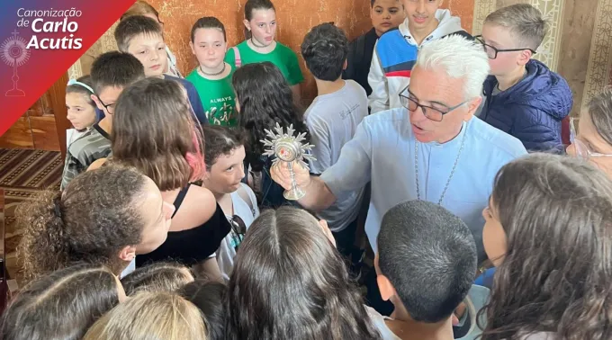 Dom Alessandro Ruffinoni mostra relíquia de Carlo Acutis a adolescentes.