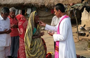 Fiéis católicos indianos recebem a comunhão durante uma missa ao ar livre na aldeia de Mitrapur, Bengala Ocidental, Índia.