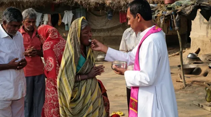 Fiéis católicos indianos recebem a comunhão durante uma missa ao ar livre na aldeia de Mitrapur, Bengala Ocidental, Índia. ?? 