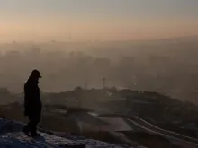 Homem observa a fumaça subindo sobre as casas em Ulaanbaatar, capital da Mongólia.