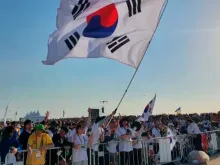 Peregrinos sul-coreanos agitam bandeira na missa com o papa Francisco para o encerramento da Jornada Mundial da Juventude 2023, em Lisboa, no dia 6 de agosto de 2023.