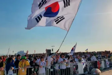 Peregrinos sul-coreanos agitam bandeira na missa com o papa Francisco para o encerramento da Jornada Mundial da Juventude 2023, em Lisboa, no dia 6 de agosto de 2023.
