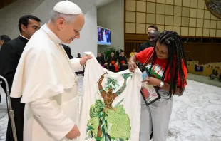 Papa Leão XIV recebe da militante do MST Ayala Ferreira uma imagem de orixá feita com miçangas do candomblé.