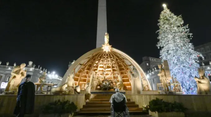 Papa Francisco contempla o presépio da praça de São Pedro após a oração das vésperas na noite do ano novo, 31 de dezembro de 2022. ?? 