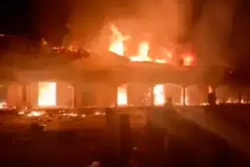 Uma captura de tela do vídeo cedido com a ACI África que mostra a casa paroquial de São Rafael Fadan Kamantan totalmente em chamas