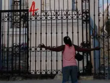Uma mulher haitiana ajoelhada em oração em frente à Catedral de Porto Príncipe, capital do país.