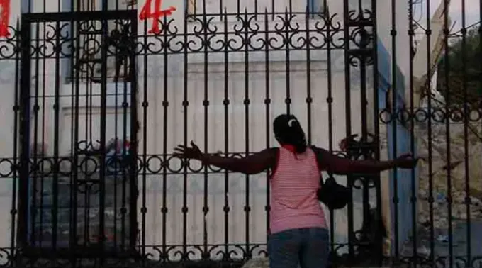 Uma mulher haitiana ajoelhada em oração em frente à Catedral de Porto Príncipe, capital do país. ?? 