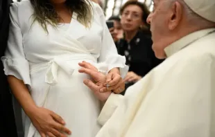 Papa Francisco abençoa uma mulher grávida.