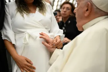 Papa Francisco abençoa uma mulher grávida.