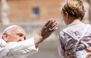 Imagem ilustrativa do papa Francisco saudando um menino durante a audiência geral