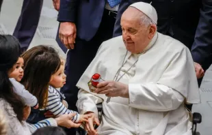Papa Francisco dá um presente a uma criança no final de sua audiência geral semanal na Sala Paulo VI do Vaticano, em 3 de janeiro de 2024.