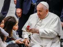 Papa Francisco dá um presente a uma criança no final de sua audiência geral semanal na Sala Paulo VI do Vaticano, em 3 de janeiro de 2024.