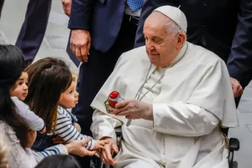 Papa Francisco dá um presente a uma criança no final de sua audiência geral semanal na Sala Paulo VI do Vaticano, em 3 de janeiro de 2024.