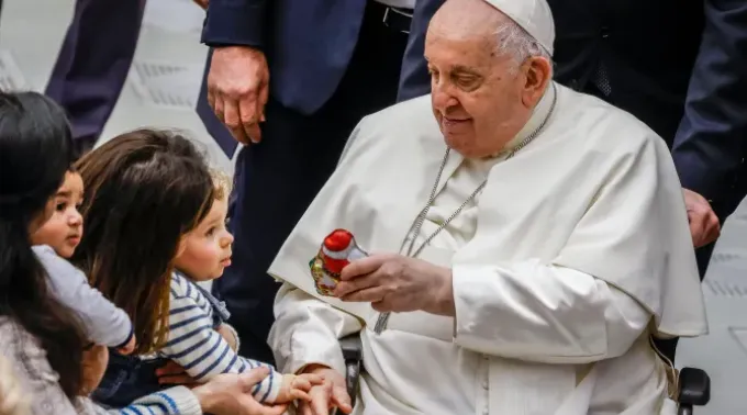 Papa Francisco dá um presente a uma criança no final de sua audiência geral semanal na Sala Paulo VI do Vaticano, em 3 de janeiro de 2024. ?? 