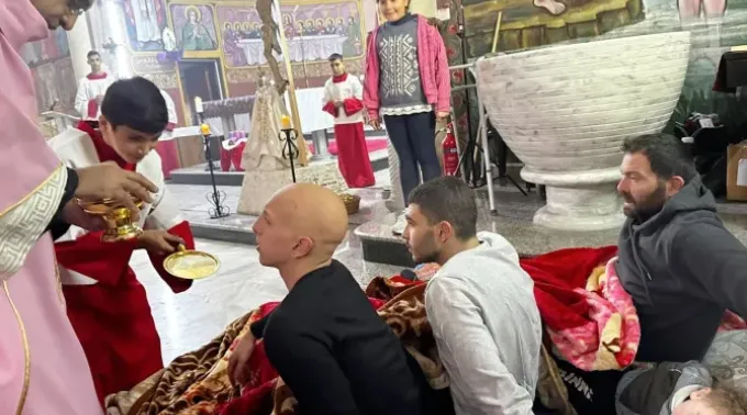 Paroquianos feridos recebem a comunhão no terceiro domingo do Advento, 17 de dezembro de 2023, na paróquia da Sagrada Família em Gaza. ?? 
