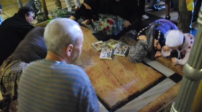 Peregrinos realizam práticas devocionais na Basílica do Santo Sepulcro em Jerusalém. ?? 
