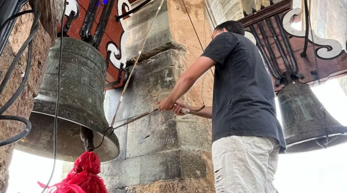 Sineiro tocando o sino em uma igreja de São João del-Rei