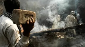 Multidão de muçulmanos joga tijolos em casa cristã depois de incendiá-la em Lahore, Paquistão, em 9 de março de 2013.