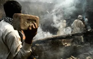 Multidão de muçulmanos joga tijolos em casa cristã depois de incendiá-la em Lahore, Paquistão, em 9 de março de 2013.