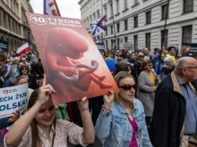 Manifestantes pró-vida com cartaz mostrando nascituro na Marcha pela Vida em Varsóvia, Polônia, em 14 de abril de 2024.