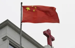 Bandeira chinesa tremula ao lado de cruz em igreja em Pingtan, China, em 15 de janeiro de 2024.
