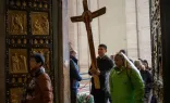 Peregrinos cruzam a porta santa da basílica de São Pedro, no Vaticano.