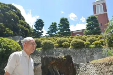 Shigemi Fukahori em frente à antiga torre do sino da catedral de Urakami em Nagasaki