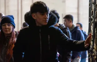 Peregrinos cruzam a porta santa da basílica de São Pedro, no Vaticano.