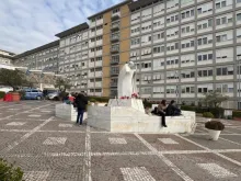 Estátua de são João Paulo II no Hospital Gemelli, em Roma, tem velas acesas pela saúde do papa Francisco.
