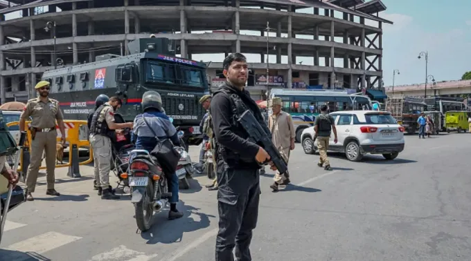 Policial guarda posto de controle em rua de Srinagar ?? 