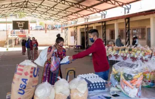 Distribuição de alimentos pela Catholic Relief Services para crianças em idade escolar em escola do departamento de Totonicapán, Guatemala, com a ajuda de pais voluntários.