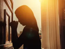 Moça rezando. Imagem referencial.