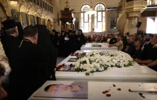 Enlutados se reúnem na terça-feira (24) na igreja da Santa Cruz em Qassaa, Damasco, Síria, ao redor dos caixões brancos de alguns dos fiéis que morreram num ataque terrorista na igreja ortodoxa grega de Santo Elias, no bairro de Dweila, em Damasco, no último domingo (22).