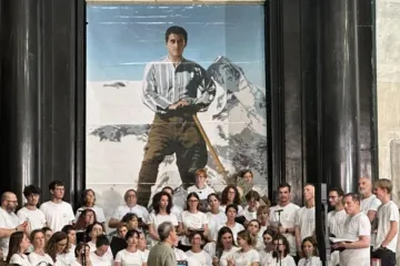 Coral posa diante de uma imagem do beato Pier Giorgio Frassati na celebração do centenário de sua morte em Turim
