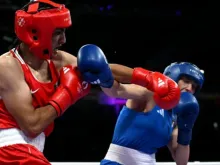 Imane Khelif, da Argélia (de vermelho), dá um soco na italiana Angela Carini na luta de boxe feminina das oitavas de final da categoria até 66 kg, na Olimpíada Paris 2024, na Arena Norte de Paris, em Villepinte, França, em 1º de agosto de 2024.