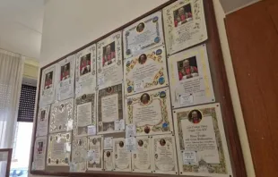 Placas penduradas no escritório da caridade papal na Cidade do Vaticano mostram diferentes modelos de certificados de bênção papal que podem ser encomendados.