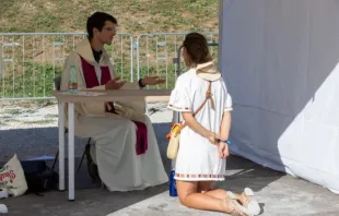 Penitente se ajoelha diante de padre em evento de confissão hoje (1) no Circo Máximo, em Roma.