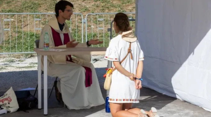 Penitente se ajoelha diante de padre em evento de confissão no Circo Máximo, em Roma, em 1° de agosto de 2025 ?? 