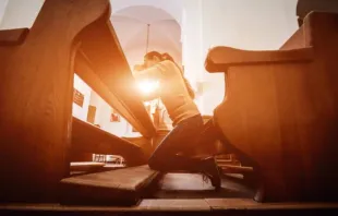 Mulher rezando. Imagem referencial.