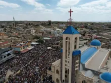 Moradores celebram o Domingo de Ramos carregando ramos de oliveira e folhas de palmeira numa grande procissão de cerca de 20 mil cristãos em Qaraqosh, Iraque, em 13 de abril de 2025.