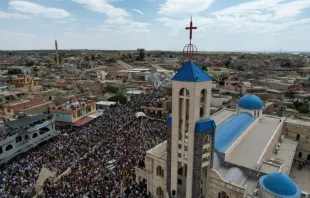 Moradores celebram o Domingo de Ramos carregando ramos de oliveira e folhas de palmeira numa grande procissão de cerca de 20 mil cristãos em Qaraqosh, Iraque, em 13 de abril de 2025.