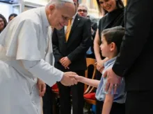O papa Leão XIV cumprimenta criança ao receber hoje (29) em audiência no Vaticano membros das Escolas de Evangelização Santo André.