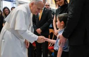 O papa Leão XIV cumprimenta criança ao receber hoje (29) em audiência no Vaticano membros das Escolas de Evangelização Santo André.