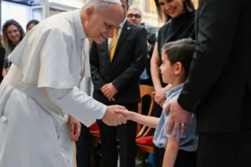 Leão XIV cumprimenta criança ao receber no Vaticano membros das Escolas de Evangelização Santo André em 29 de agosto de 2025
