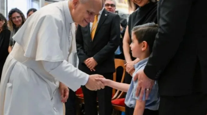 Leão XIV cumprimenta criança ao receber no Vaticano membros das Escolas de Evangelização Santo André em 29 de agosto de 2025 ?? 